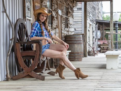 A beautiful Brunette model posing outdoors in an cowboy environment