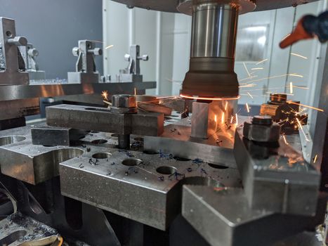 cnc milling of hardened steel with sparks - closeup with selective focus and blur.