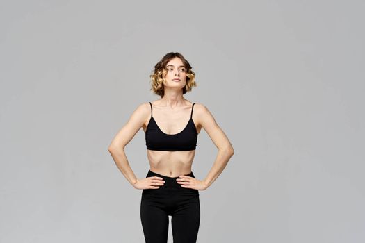 woman in short t-shirt goes in for sports on a gray background exercise exercise copy space. High quality photo