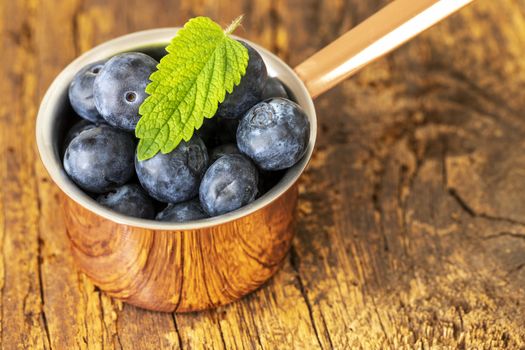 blue berries in a pot on wood