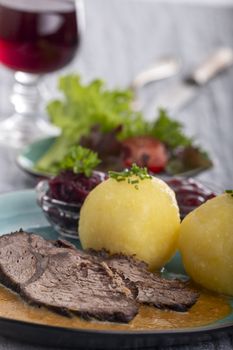 german sauerbraten on a plate with dumplings