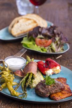 grilled meat and green asparagus on a blue plate