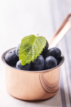 blue berries in a pot on wood