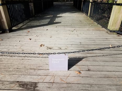 temporarily closed sign with chain and wooden boardwalk