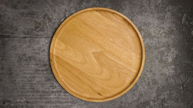 Wooden dish on gray cement table.