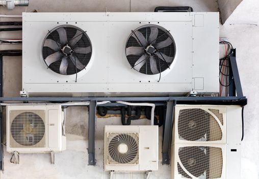 The compressor unit and air conditioners are installed on a metal frame and fixed to the wall of the old building.