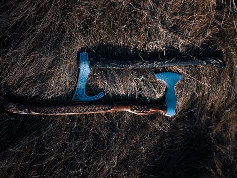 Close up look at the ancient Scandinavian vikings axe at the summer sunset on the deep grass