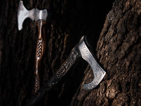 Close up look at the ancient Scandinavian vikings axe at the summer sunset on the deep grass