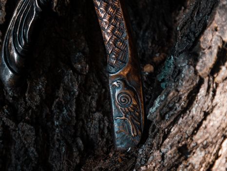 Close up look at the ancient Scandinavian vikings axe at the summer sunset on the deep grass