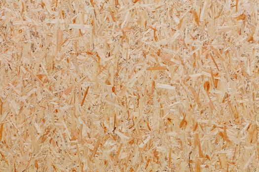 OSB, board texture and backgroundof pressed sandy brown wood shavings, closeup.