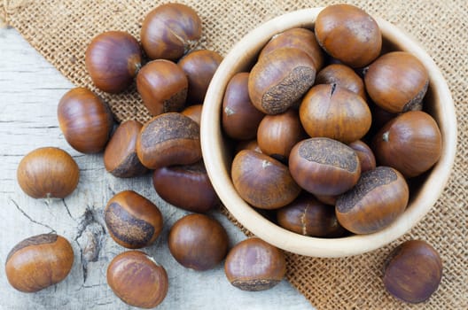 chestnuts on sackcloth and wooden floor.