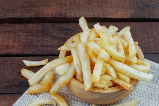 French fries in a bowl on tablecloth.