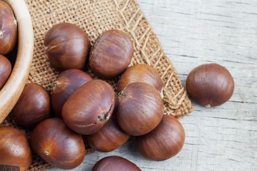 Roasted chestnuts on sackcloth and wooden floor.