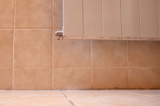 Old brown tiles in a bathroom in need of some maintenance