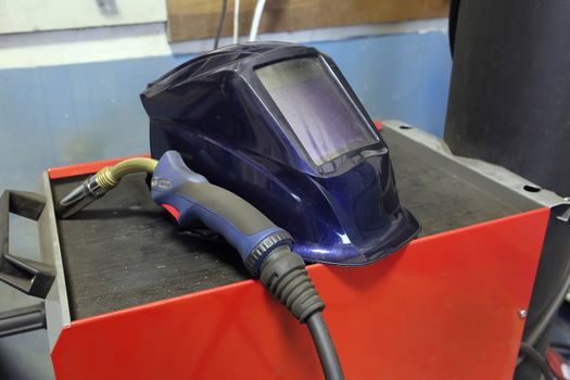 Tools for welding. Welder's protective mask, electrode for electric arc welding lies on the box for welding.