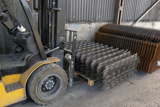 warehouse forklift carrying a stack of rebar mesh