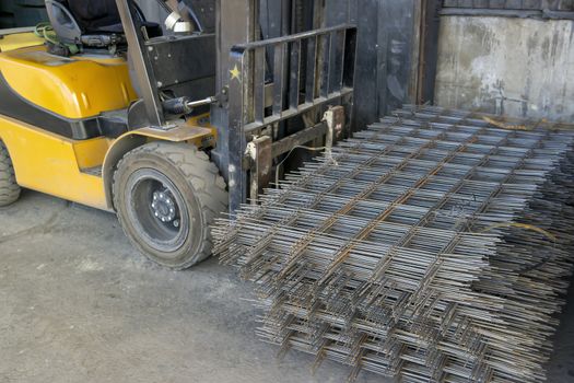 warehouse forklift carrying a stack of rebar mesh
