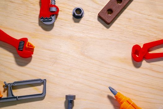 children's plastic tools lie on a sheet of plywood.Copyspace for text