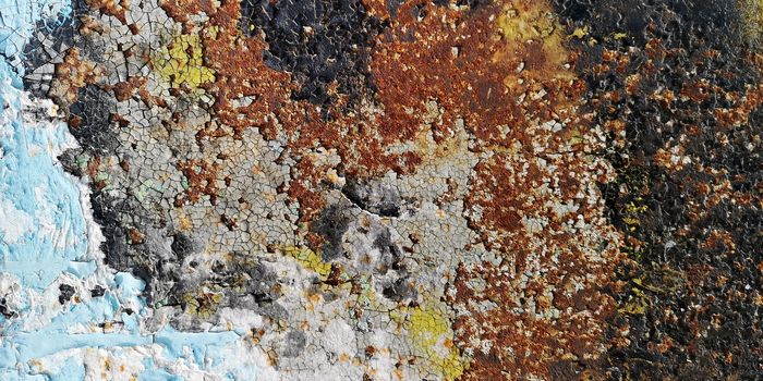 Old painted surface with rust and cracked paint. Background texture closeup.