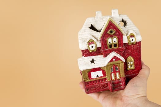 Hand holds toy house of red color. Concept of sale, purchase, rental or home insurance. Place for an inscription. Copy space