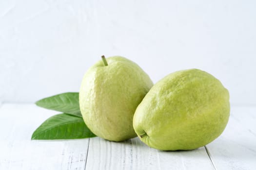 Top view, flat lay of delicious beautiful Red guava with fresh green leaves isolated on white table background, studio overhead table shot with copy space.