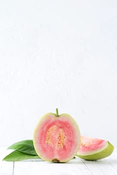 Top view, flat lay of delicious beautiful Red guava with fresh green leaves isolated on white table background, studio overhead table shot with copy space.