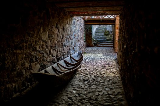 Old wooden boat on a stone paving. The concept of unfulfilled hopes, unfulfilled plans, old age of weakness or helplessness.