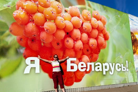 Belarus, Belarusians. A happy girl on the background of a poster that says I am Belarus in Belarusian. 31.07.2018 Minsk, Belarus