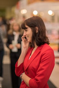 Woman speaking on her phone attending an event at the convention trade center in Brno. BVV Brno Exhibition center. Czech Republic