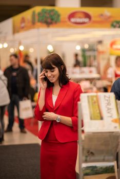 Woman speaking on her phone attending an event at the convention trade center in Brno. BVV Brno Exhibition center. Czech Republic