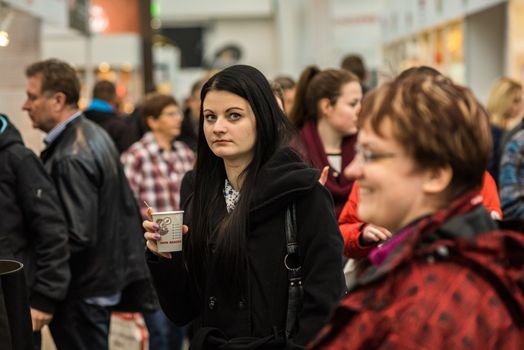 Man and woman walking in the crowd attending an event at the convention trade center in Brno. BVV Brno Exhibition center. Czech Republic