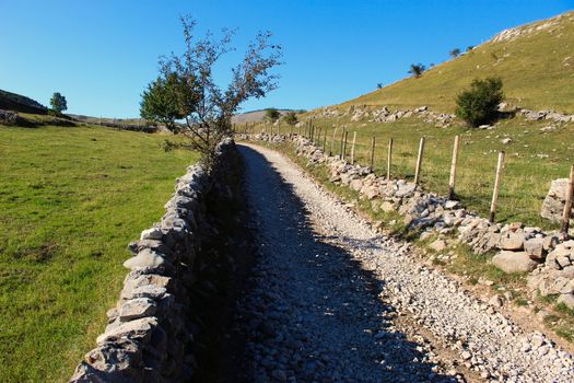 Large stones stacked in the wall to fence off the field from the road. Road to the old Bosnian village of Lukomir. Bjelasnica Mountain, Bosnia and Herzegovina.