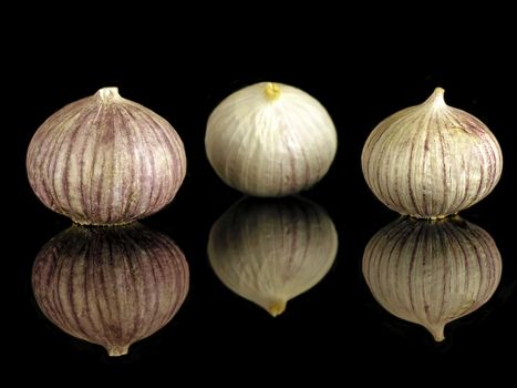 chinese round garlic on a black mirror