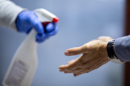 Spraying hands with antiseptic solution