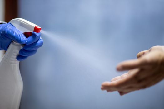 Spraying hands with antiseptic solution