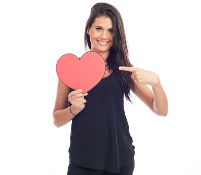 beautiful happy brunette woman holding and showing a big red heart