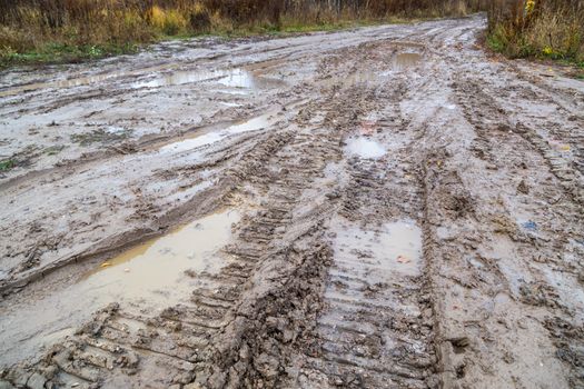 dirty clay mud road with tire tracks - closeup with selective focus and field blur