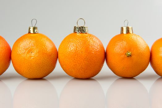 Tangerines as a xmas ball on Christmas and New Year. Russian tradition fir tree toy fruits holiday concept decoration design on holiday. Tangerines Row Line Isolated on white background.