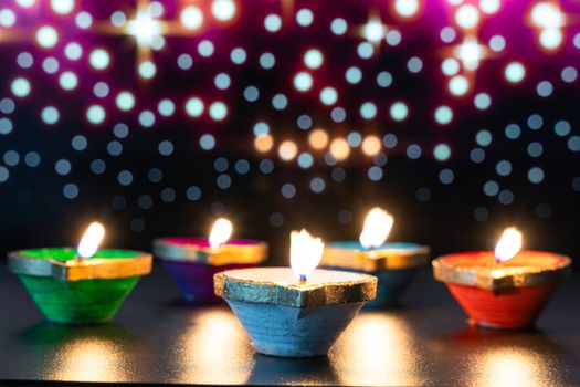 Indian festival Diwali, Diya oil lamps lit on colorful rangoli. Hindu traditional. Happy Deepavali. Copy space for text.