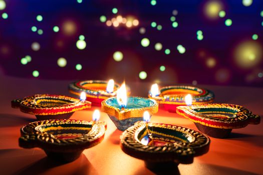 Indian festival Diwali, Diya oil lamps lit on colorful rangoli. Hindu traditional. Happy Deepavali. Copy space for text.