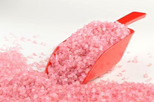 A red scoop of strawberry pink bath salts.