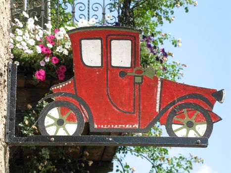 Store sign made of metal in form of a car.