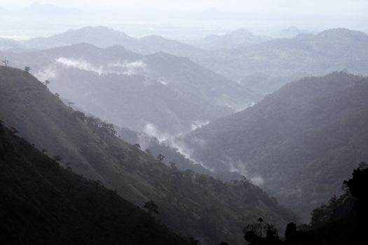 Ella Sri Lanka mountain gap landscape views across the wide valley to mountains in the distance misty early morning Adams Peak. High quality photo