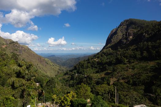 Ella Sri Lanka mountain gap landscape views across the wide valley to mountains in the distance against blue skies with clouds Adams Peak. High quality photo