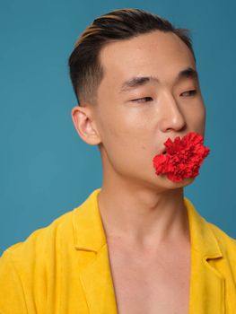 Handsome Asian man with a flower in his teeth and a yellow coat fashion . High quality photo