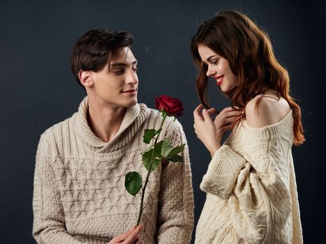 Man and woman gives rose flower romance dark studio background