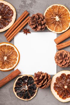 Christmas mockup composition. Cinnamon, anise, dried fruits and pine cones decorations on grey background