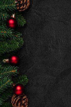 Christmas composition. Colorful ornament, pine cones and fir needles decorations on dark background. Top view copy space