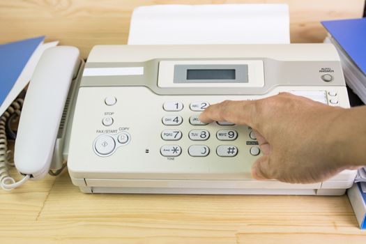 hand man are using a fax machine in the office, equipment for data transmission.