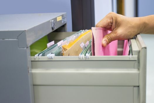 Hand of Man Search files document in a file cabinet in work office, concept business office life.